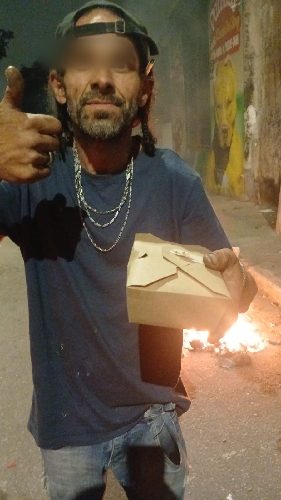 Beneficiário recebendo uma refeição durante uma entrega noturna